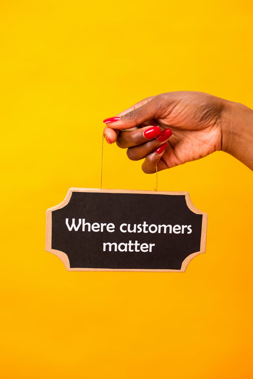 yellow background and a hand holding a small black board; Get the secrets of Customer relationship management
