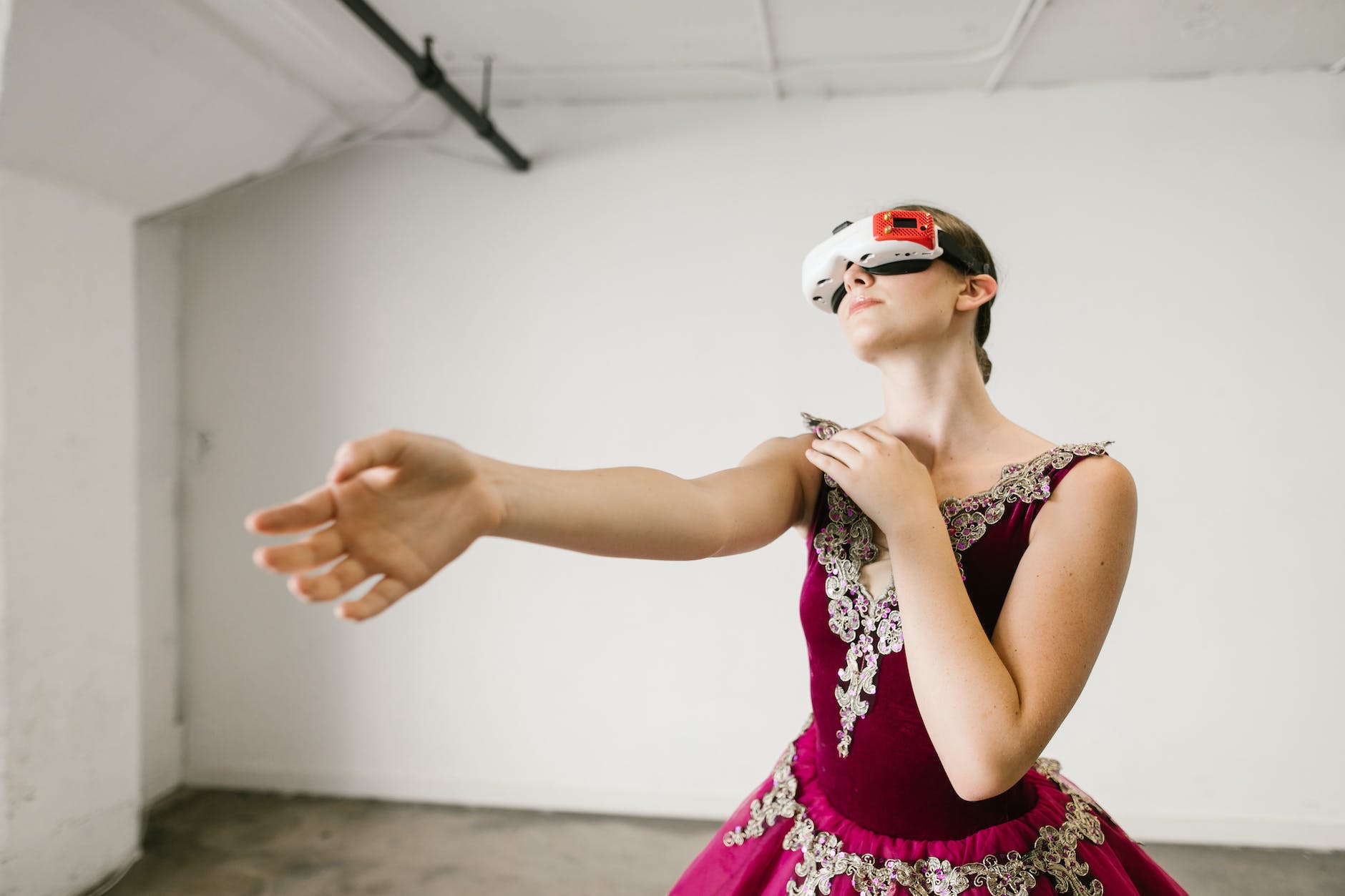 a woman in a red dress dancing while wearing a vr headset